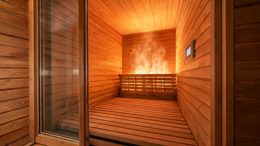 A premium cedar infrared sauna cabin photographed at a low three-quarter angle, interior panels glowing warm amber from…