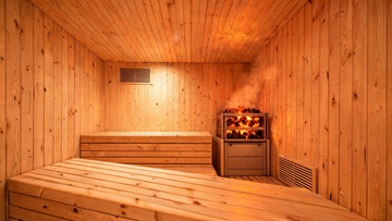 A beautifully constructed home sauna interior in Grade-A Canadian cedar, viewed from the bench level looking toward the…