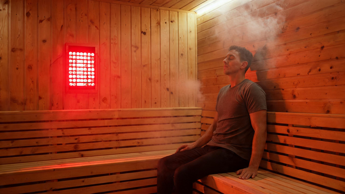 9) — Warm cedar sauna interior with a wall-mounted red light panel glowing, one person seated calmly; steam-lit, Cedar…