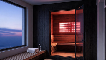[IMAGE 1 — HERO 16:9: warm cedar infrared cabin in a Canadian home wellness room, red/near-infrared LED panel glowing on the…