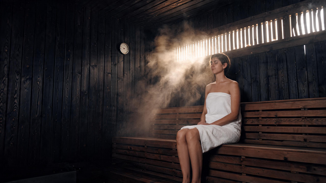 9) — interior of a warm black-cedar sauna, single person seated calmly, soft steam, wood-grain detail, low golden light.…