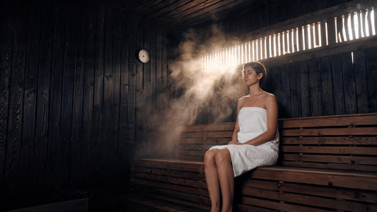 9) — interior of a warm black-cedar sauna, single person seated calmly, soft steam, wood-grain detail, low golden light.…