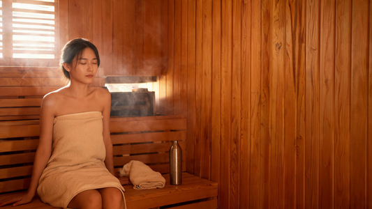 9) — Calm, steam-softened cedar sauna interior with warm low light; a person sitting relaxed, towel and water bottle nearby.…