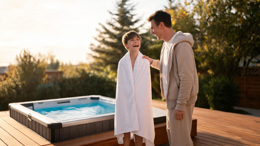 A parent and an older child laughing together beside a small home cold plunge on a cedar deck in a Canadian backyard