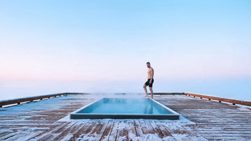 A single sleek cold plunge on a clean snow-dusted dock at first light, a spare minimalist Canadian winter scene