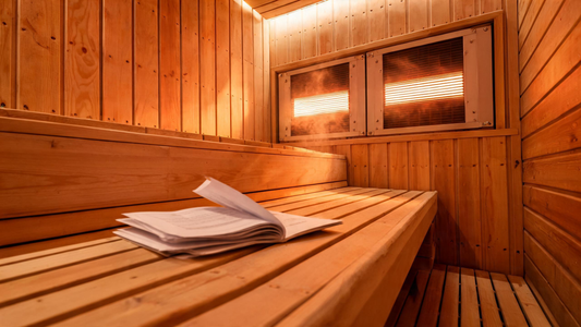 An open interior of a two-person infrared sauna with Grade-A Canadian Western Red Cedar walls glowing warm amber under near-infrared heater panels, tight
