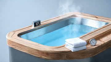A sleek cedar-trimmed cold plunge tub viewed at a low three-quarter angle, Glacier-blue water still and faintly misted, a visible digital temperature