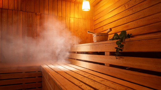 Interior of a Canadian cedar sauna at golden-hour warmth — cedar bench, smooth Grade-A cedar walls glowing amber from…