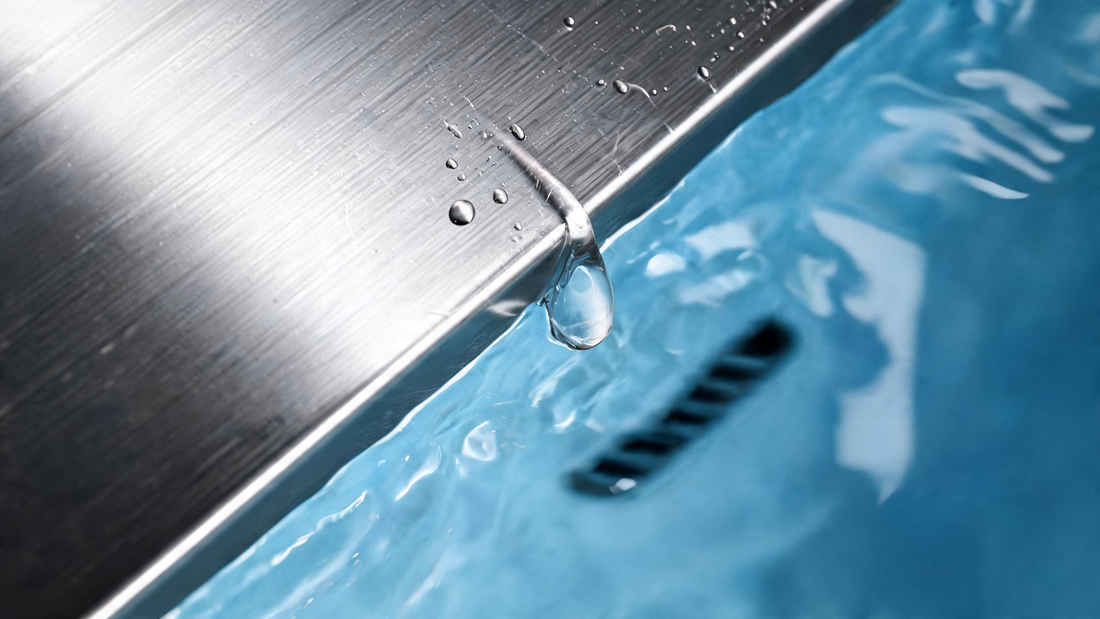 Brushed 316 stainless steel cold plunge beside a glossy white acrylic cold plunge shell in a dark cedar room, Glacier-blue water in both
